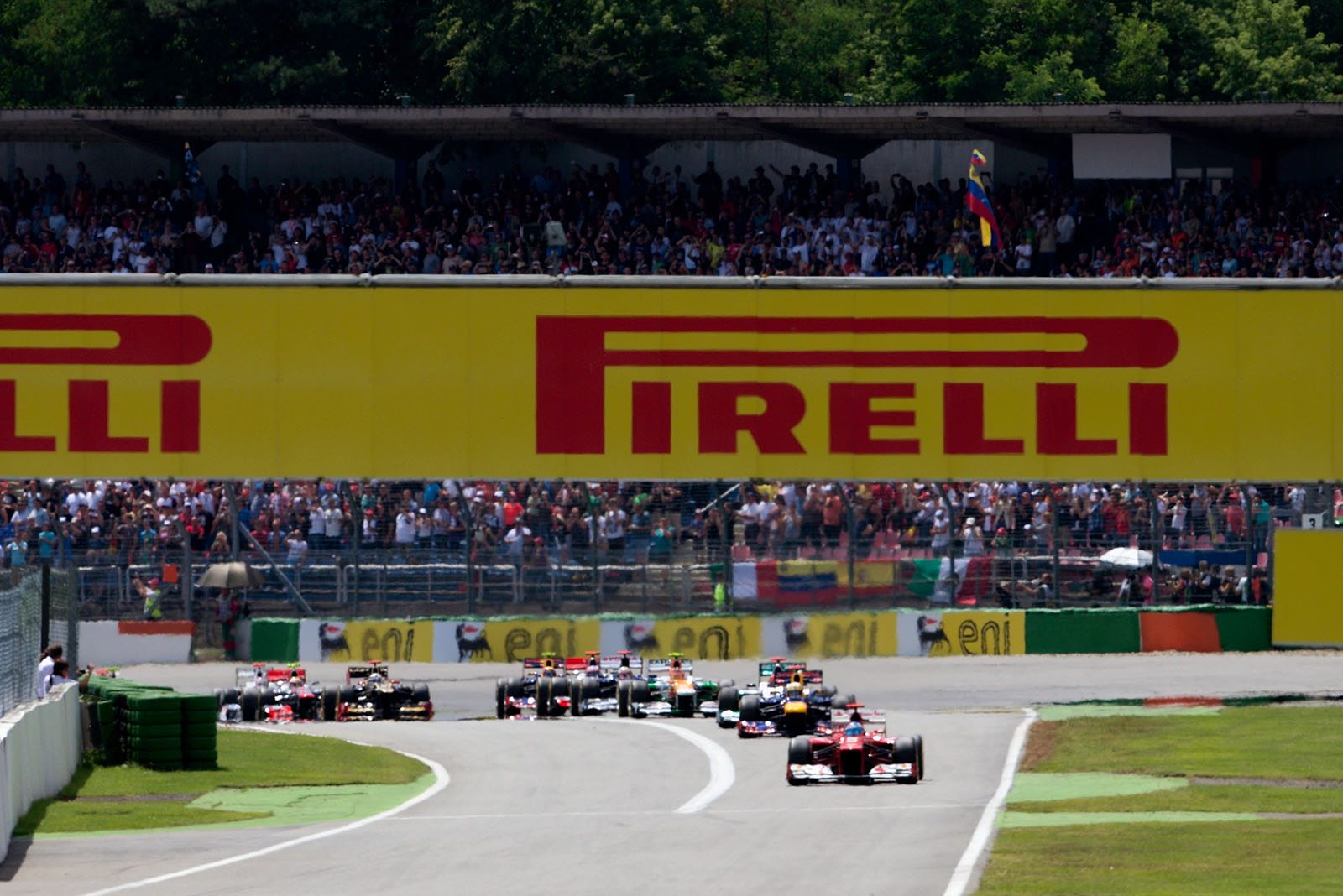 The start field with Ferrari's Alonso in the lead approaches turn two